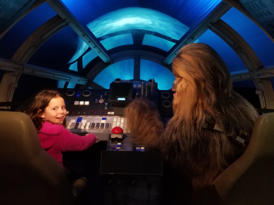 Child in the Millennium Falcon cockpit with Chewbacca at Madame Tussaud's London's Star Wars exhibition. Photo by Anastasia Mills Healy.